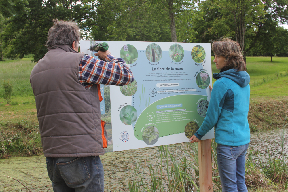 Pose de l'affiche de la Mare à la Pyramide du Loup